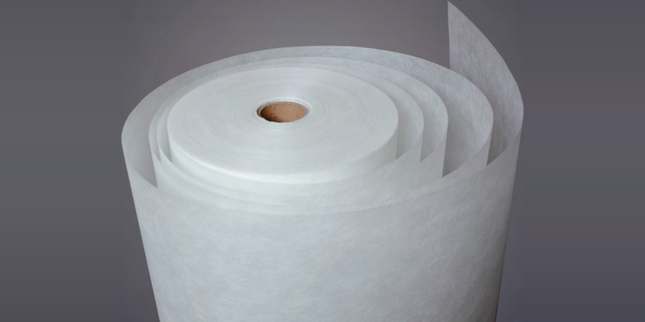 Wet-laid fiberglass paper roll for desiccant rotor substrates on a gray background