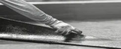 Industrial roofing waterproofing installation using high-tensile fiber mat reinforcement.